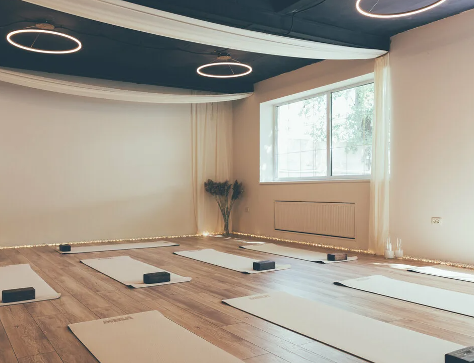 Open-air yoga deck on top of a hotel building in Madrid with wooden flooring and soft lights